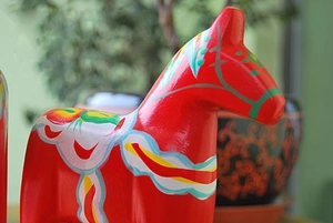 Close-up of a red wooden Dala horse with traditional Nordic hand-painted floral patterns