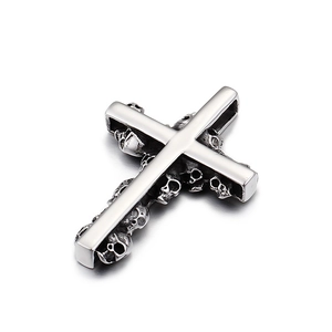 Polished silver stainless steel cross pendant featuring intricate skull engravings