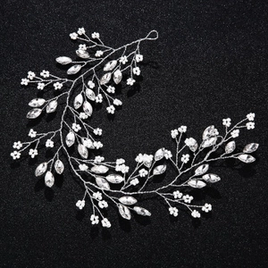 Close-up of silver leaf bridal headband with sparkling rhinestones and white pearls