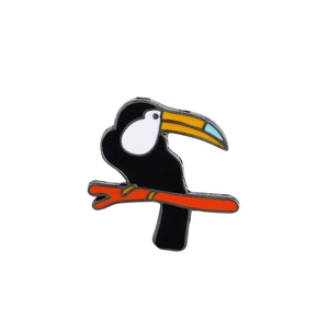 Macro shot of a colorful enamel toucan brooch pin with vibrant black and orange hand-painted details