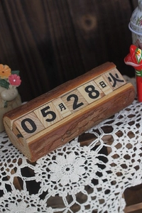 Détail d'un calendrier perpétuel en bois avec écorce naturelle sur dentelle