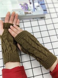 Detail of army green cable knit fingerless gloves with elongated cuffs and thumb holes