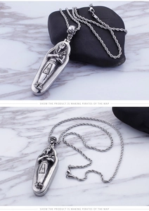 Macro detail of vintage silver Pharaoh Sarcophagus pendant with skull and rope chain