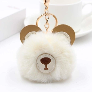 Detail of plush bear keychain with faux fur ball and rose gold metal clasp hardware