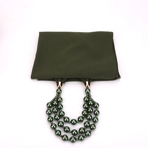Detail of dark green chiffon scarf with triple-layer faux pearl necklace pendant