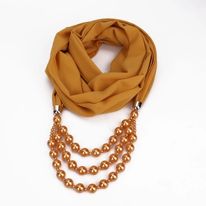 Detail der senfgelben Chiffon-Schalkette mit dreilagigen goldenen Kunstperlen