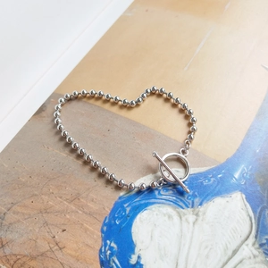 Detail of silver round bead bracelet with toggle clasp arranged in a heart shape
