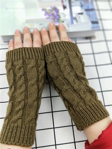 Detail of olive green cable-knit fingerless gloves with a long sleeve design for warmth