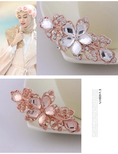 Close-up of sparkling crystal flower hair clips with rose gold base in white and champagne