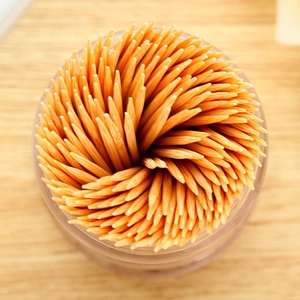 Bamboo toothpicks arranged in a spiral pattern within a transparent portable container