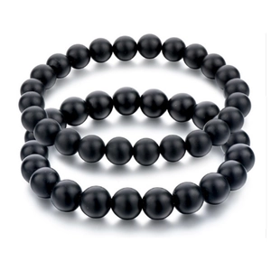 Detailed macro view of two 8mm matte black onyx beaded bracelets on white background
