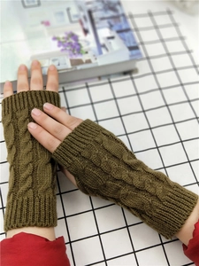 Close-up of olive green cable knit fingerless gloves with extended wrist and thumb hole