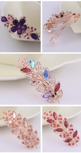 Detail view of multi-color crystal rhinestone flower hair clips on ceramic plate