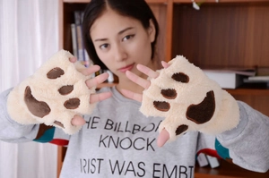 Close-up of fluffy cream-colored cat paw fingerless gloves with brown paw pad details