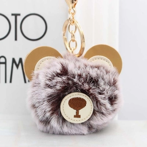Close-up of cute brown spotted plush bear keychain with premium golden lobster clasp