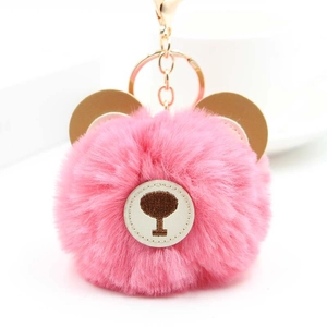 Detailed view of pink faux fur bear keychain with golden metal ring and lobster clasp