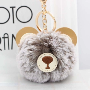 Close-up of cute brown bear plush keychain with faux rabbit fur and golden metal ring