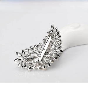 Macro shot of silver-plated brooch back with safety pin and sparkling rhinestone details