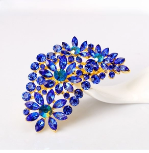 Close-up of blue marquise crystals and rhinestones set on a gold flower brooch