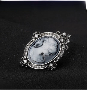 Detail of vintage cameo brooch with silver metal base and sparkling rhinestones