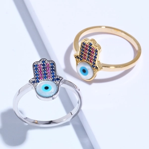 Detailed view of gold and silver Hamsa Hand rings with blue Evil Eye and colorful zircons