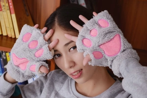 Close-up of grey plush cat paw fingerless gloves with soft pink padded palm detail