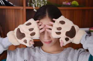 Close-up of cute plush cat paw fingerless gloves with brown pads on beige faux fur