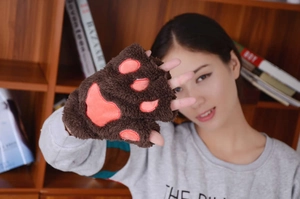 Detailed macro of brown plush cat paw gloves with soft pink heart shaped pads
