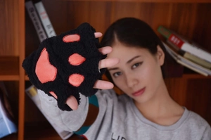 Detail of plush black cat paw fingerless gloves with pink paw pads on palm