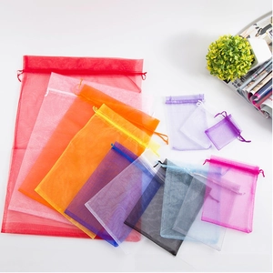 Macro detail of various colorful organza gift bags with drawstrings on white background