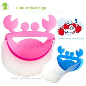 Close-up of pink and blue crab-shaped faucet extenders for children's hand washing