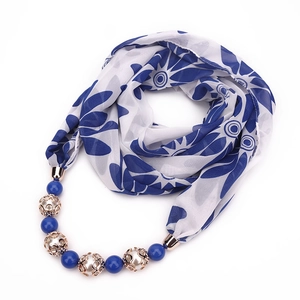 Detail of floral chiffon scarf with blue beads and gold hollow metal necklace charms