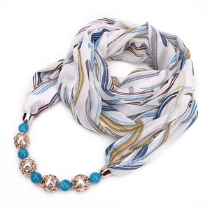 Detail of chiffon scarf featuring blue beads and rose gold hollow charms with leaf prints