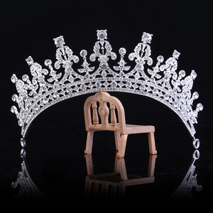 Elegant silver bridal crown with shimmering crystals on a black reflective background