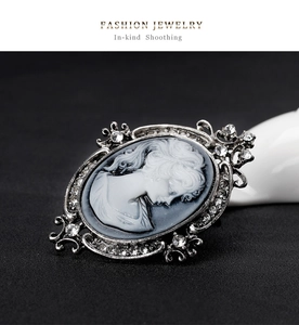 Macro shot of vintage cameo brooch with crystal accents and silver floral metal frame