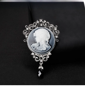 Macro shot of vintage cameo brooch with crystals and a black teardrop crystal pendant