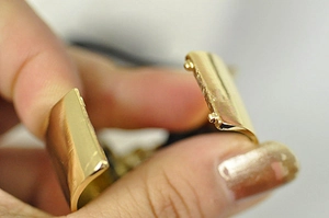 Detail shot of the golden alloy ponytail cuff buckle showing functional opening mechanism