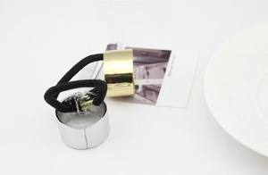 Close-up of gold and silver ponytail cuffs with elastic bands on a white surface