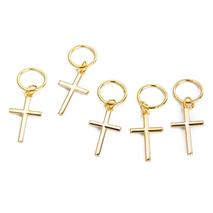 Set of five golden metal hair clips with cross pendants on a white background
