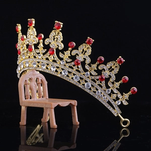 Luxurious gold bridal crown with red and clear rhinestones on a vintage prop