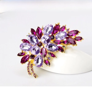 Macro shot of purple and pink crystal flower brooch with gold plating detail