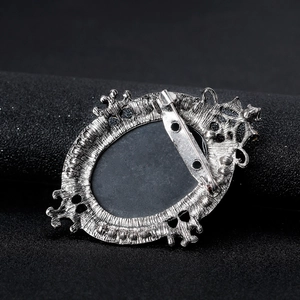 Back view of vintage silver alloy cameo brooch with pin closure and ornate patterns
