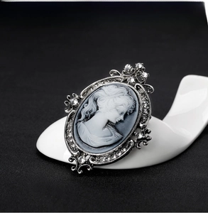 Macro shot of vintage cameo brooch featuring white profile on grey with crystal inlay
