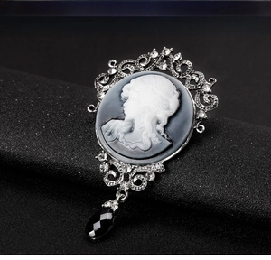 Macro detail of Victorian cameo brooch with white portrait and black crystal drop