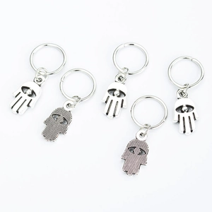 Detailed macro shot of silver Hamsa hand charms for hair braids and DIY jewelry