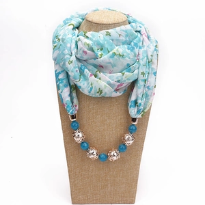 Detail of teal floral chiffon necklace scarf with blue beads and golden hollow charms