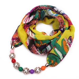 Detail of colorful chiffon scarf necklace with vibrant abstract print and beaded pendant