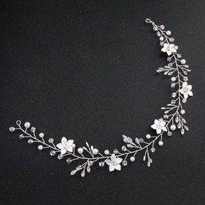 Detail of silver bridal headband with white flowers, pearls, and sparkling crystals