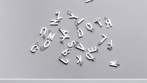 Vue macro des breloques lettres alphabet en argent S925 pour bijoux et bracelets DIY