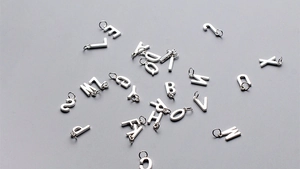 Vue macro de breloques lettres alphabétiques en argent S925 pour création de bijoux